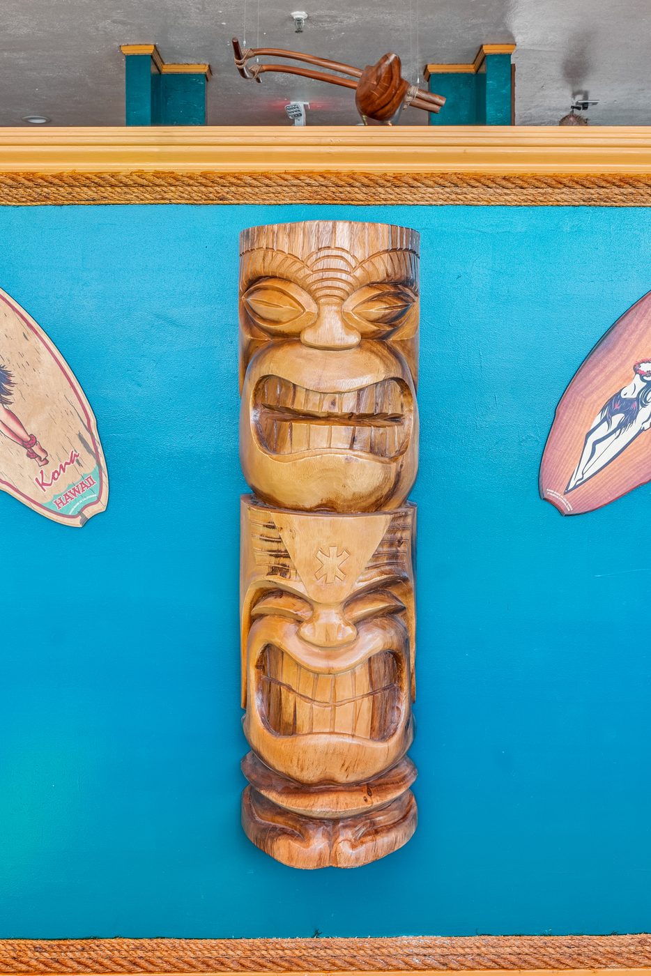 Carved tiki statue on teal wall